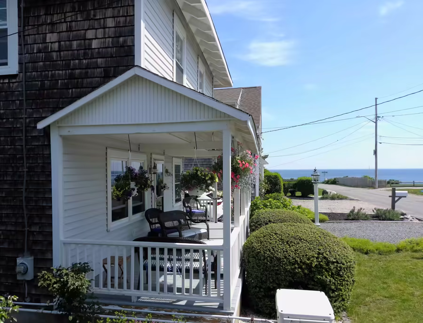 The real wraparound porch with hanging flower baskets, looking down the street to the Atlantic